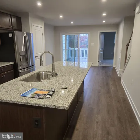 a large kitchen with stainless steel appliances wooden floors and wooden cabinets
