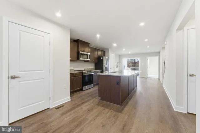 a kitchen with stainless steel appliances a refrigerator and wooden floor