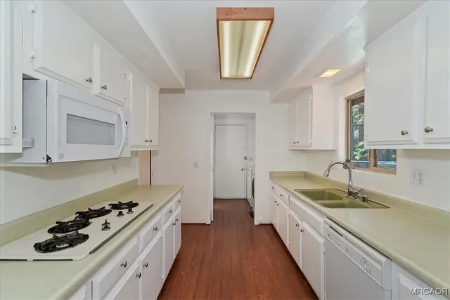 a kitchen with a sink stove top oven and cabinets