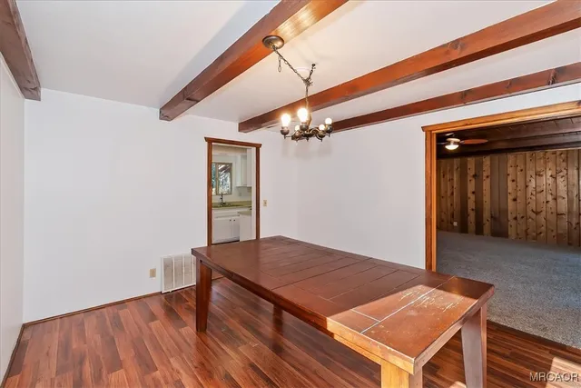 an outdoor space with wooden floor and fan