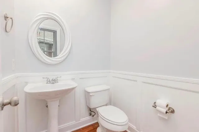a bathroom with a toilet a sink and a mirror