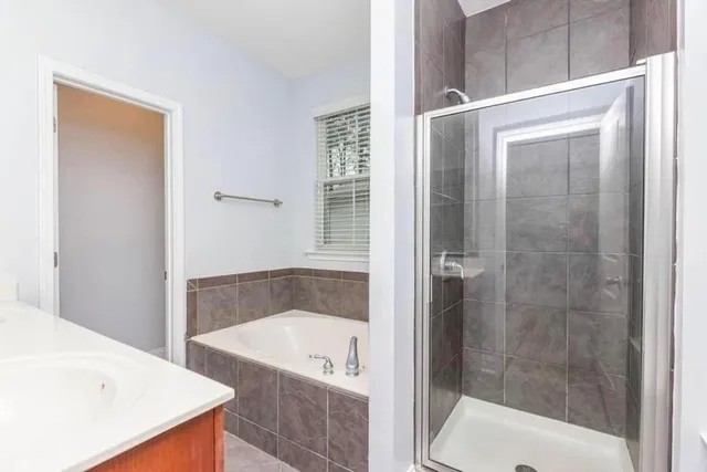 a bathroom with a tub shower and sink