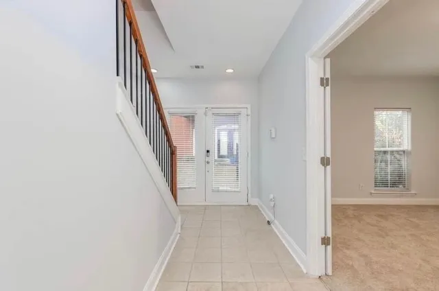 a view of a hallway with wooden floor and staircase