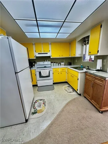 a kitchen with a sink a stove and cabinets