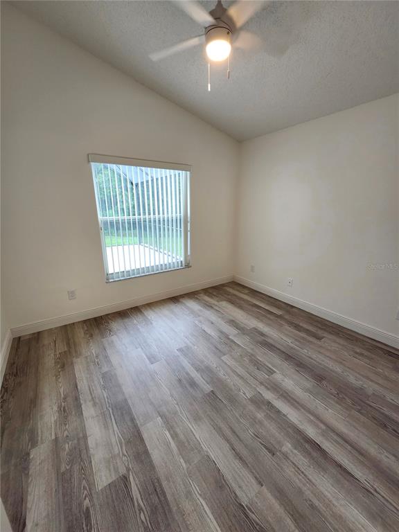4694 Prairie Point Boulevard Kissimmee, FL 34746 - Photo 12 of 23 an empty room with wooden floor and windows