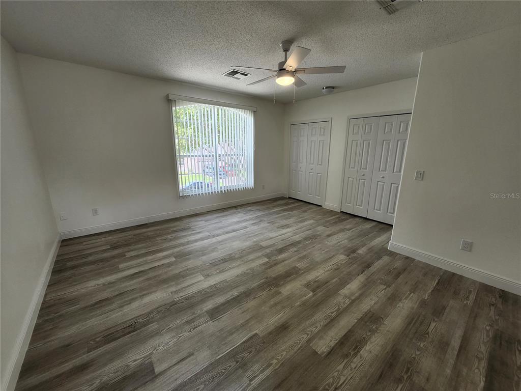 4694 Prairie Point Boulevard Kissimmee, FL 34746 - Photo 17 of 23 a view of an empty room with wooden floor and a window