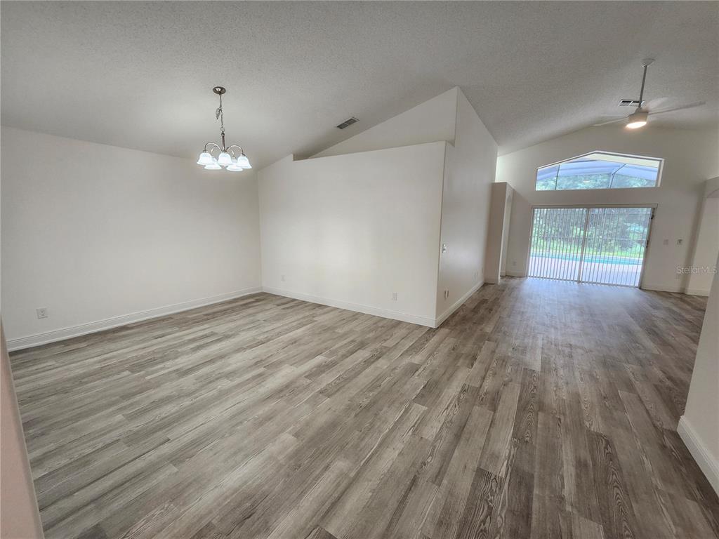 4694 Prairie Point Boulevard Kissimmee, FL 34746 - Photo 5 of 23 wooden floor in an empty room with a window