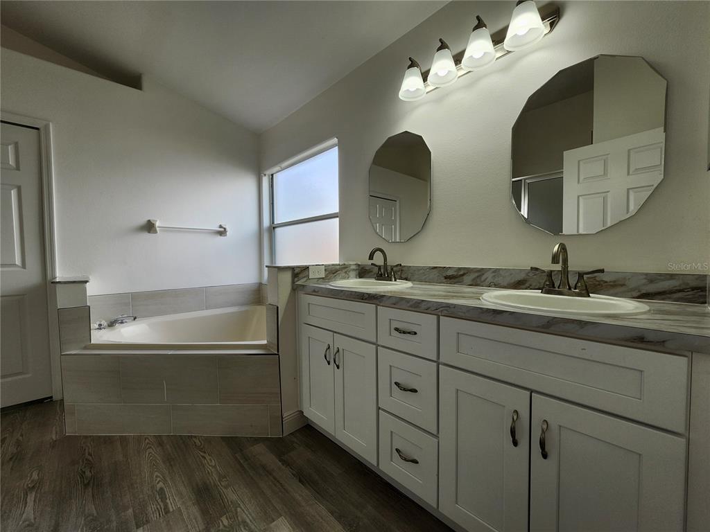 4694 Prairie Point Boulevard Kissimmee, FL 34746 - Photo 8 of 23 a bathroom with a double vanity sink and a mirror