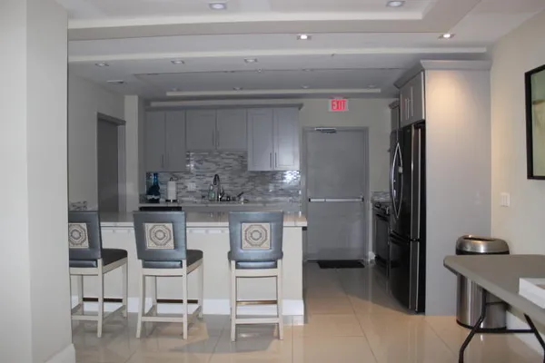 a kitchen with stainless steel appliances kitchen island granite countertop a table and chairs in it