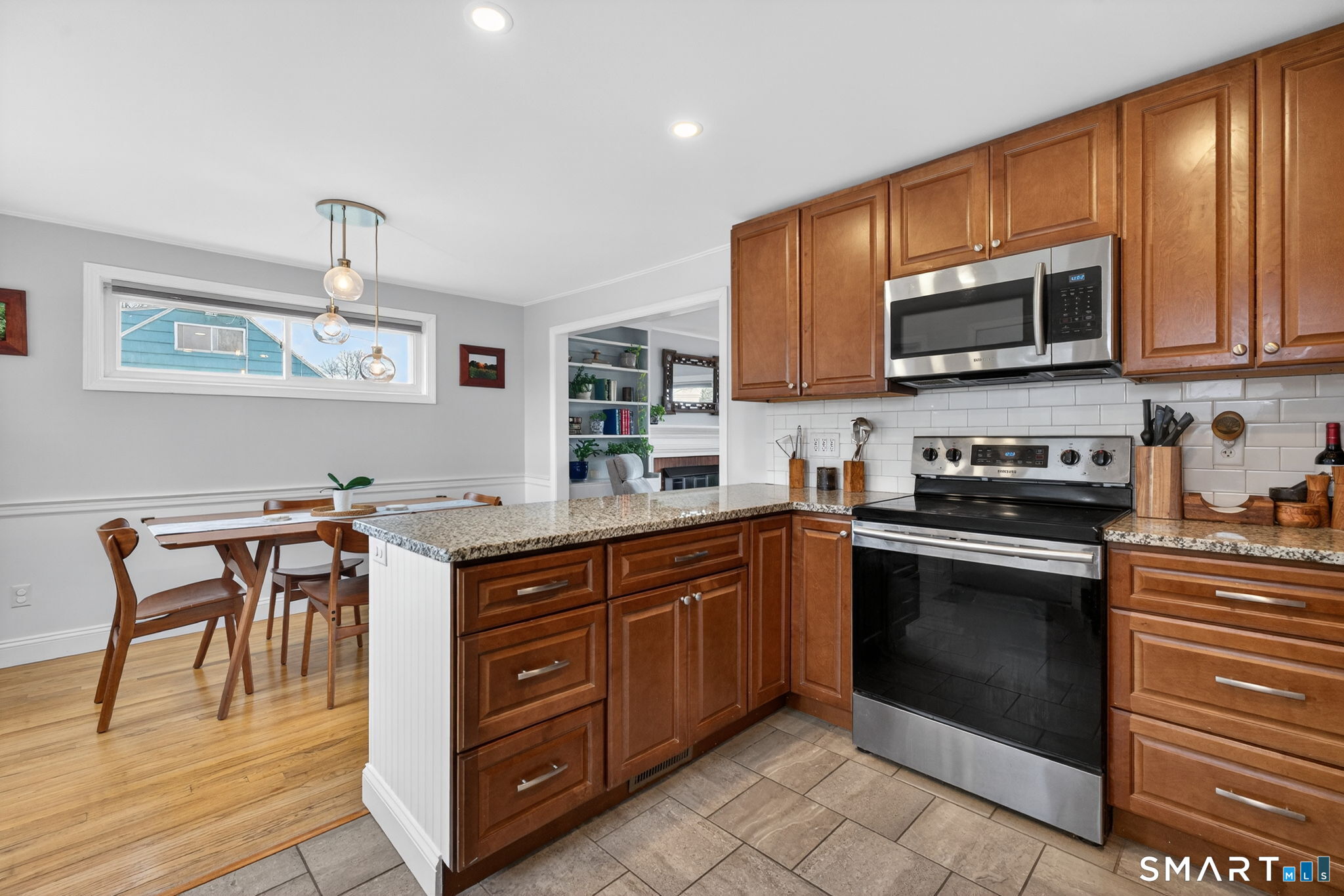 12 Lewis Street Simsbury, CT 06081 - Photo 14 of 35 a kitchen with stainless steel appliances granite countertop a stove a sink dishwasher and a microwave oven with wooden cabinets
