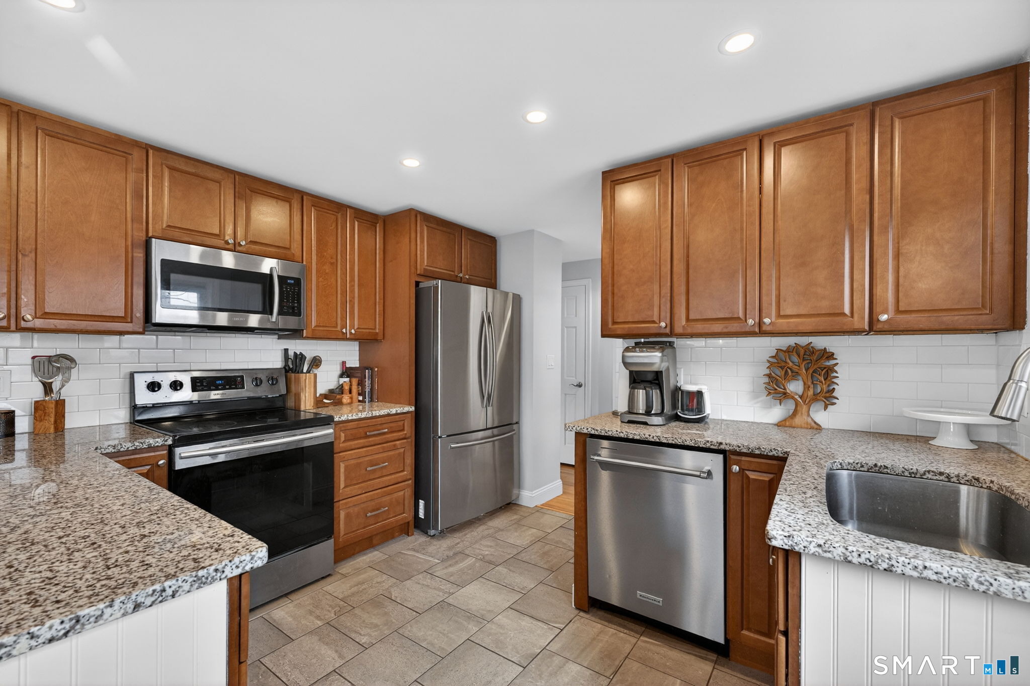 12 Lewis Street Simsbury, CT 06081 - Photo 10 of 35 a kitchen with granite countertop stainless steel appliances a sink a stove a refrigerator cabinets and a center island