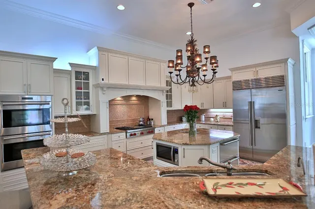 a dining room with granite countertop a stove top oven a sink dishwasher a dining table and a fireplace with wooden floor