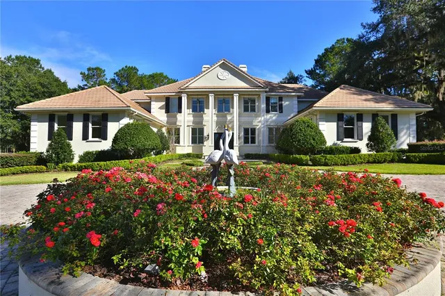a front view of a house with a big yard and potted plants