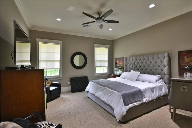 a spacious bedroom with a bed a mirror on dresser and a window
