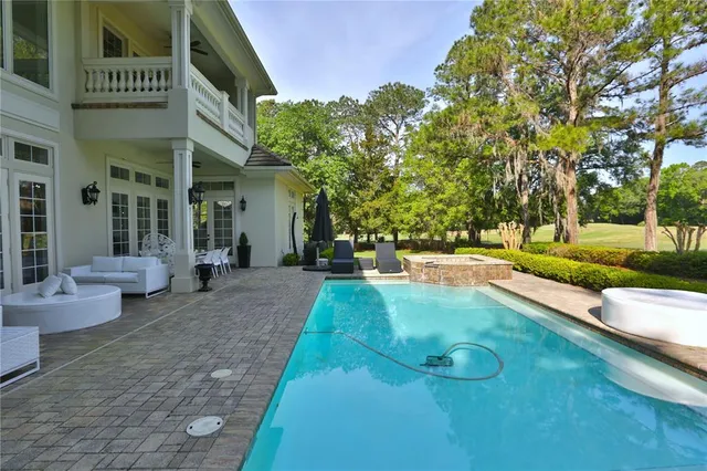 a view of a house with large pool and sitting area