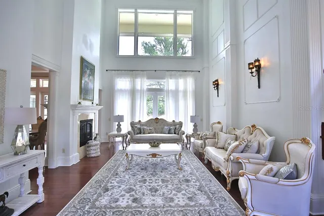 a living room with furniture and a large mirror next to a window
