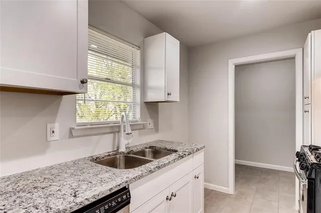 a kitchen with granite countertop a sink and a window