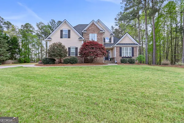 a front view of a house with a yard and trees