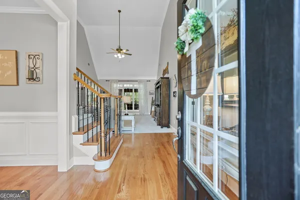 a view of a hallway with wooden floor and staircase