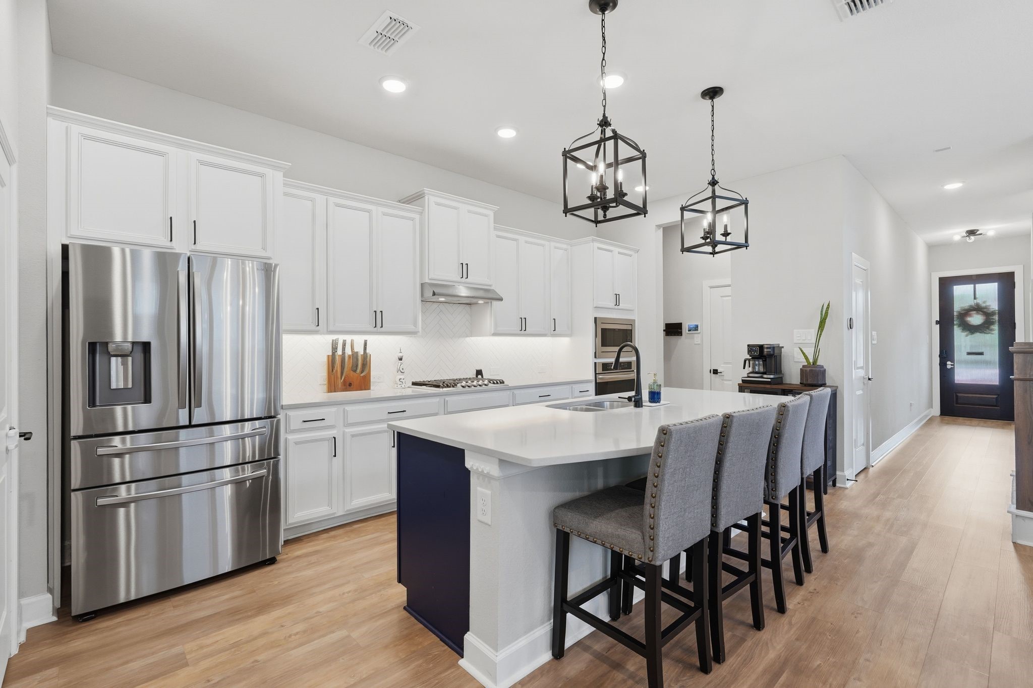 24423 Morningside Terrace Tomball, TX 77375 - Photo 2 of 47 a kitchen with stainless steel appliances granite countertop a refrigerator a sink dishwasher a stove a dining table and chairs with wooden floor