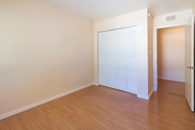 a view of an empty room with wooden floor