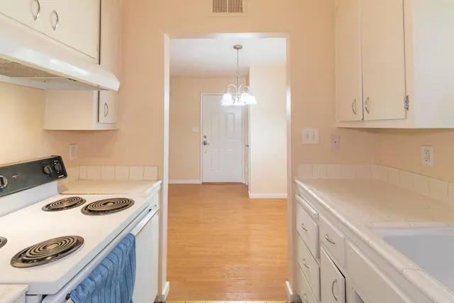 a kitchen with a sink a stove and cabinets