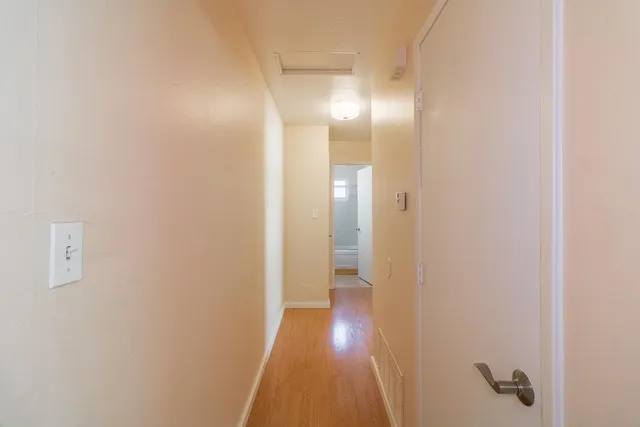 a view of a hallway with wooden floor