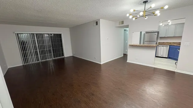 wooden floor in an empty room with a kitchen