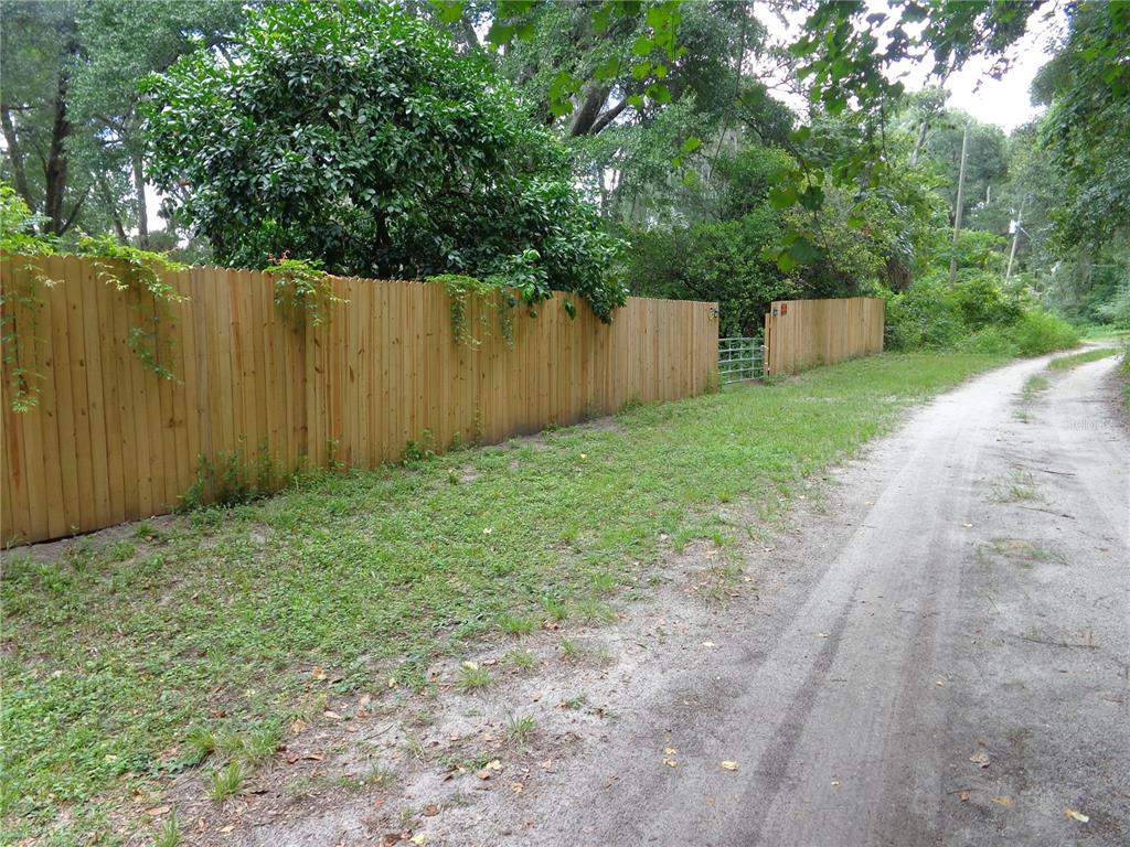 2878 Northeast 161st Street Citra, FL 32113 - Photo 38 of 38 a view of a backyard with large trees and wooden fence