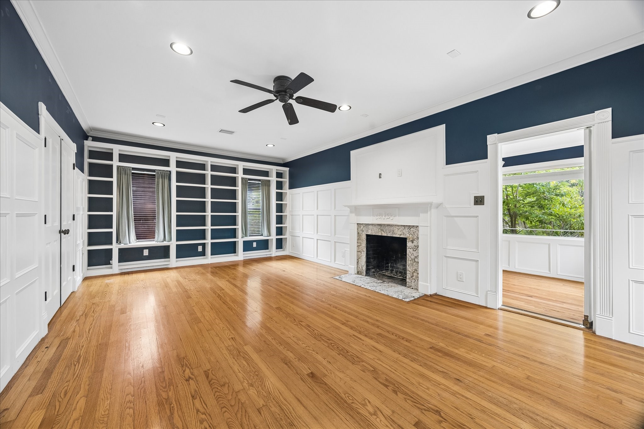 3231 North MacGregor Way Houston, TX 77004 - Photo 6 of 22 Living room featuring custom built-in bookcases and a wood-burning or gas fireplace