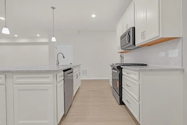 a kitchen with stainless steel appliances granite countertop a sink and a stove