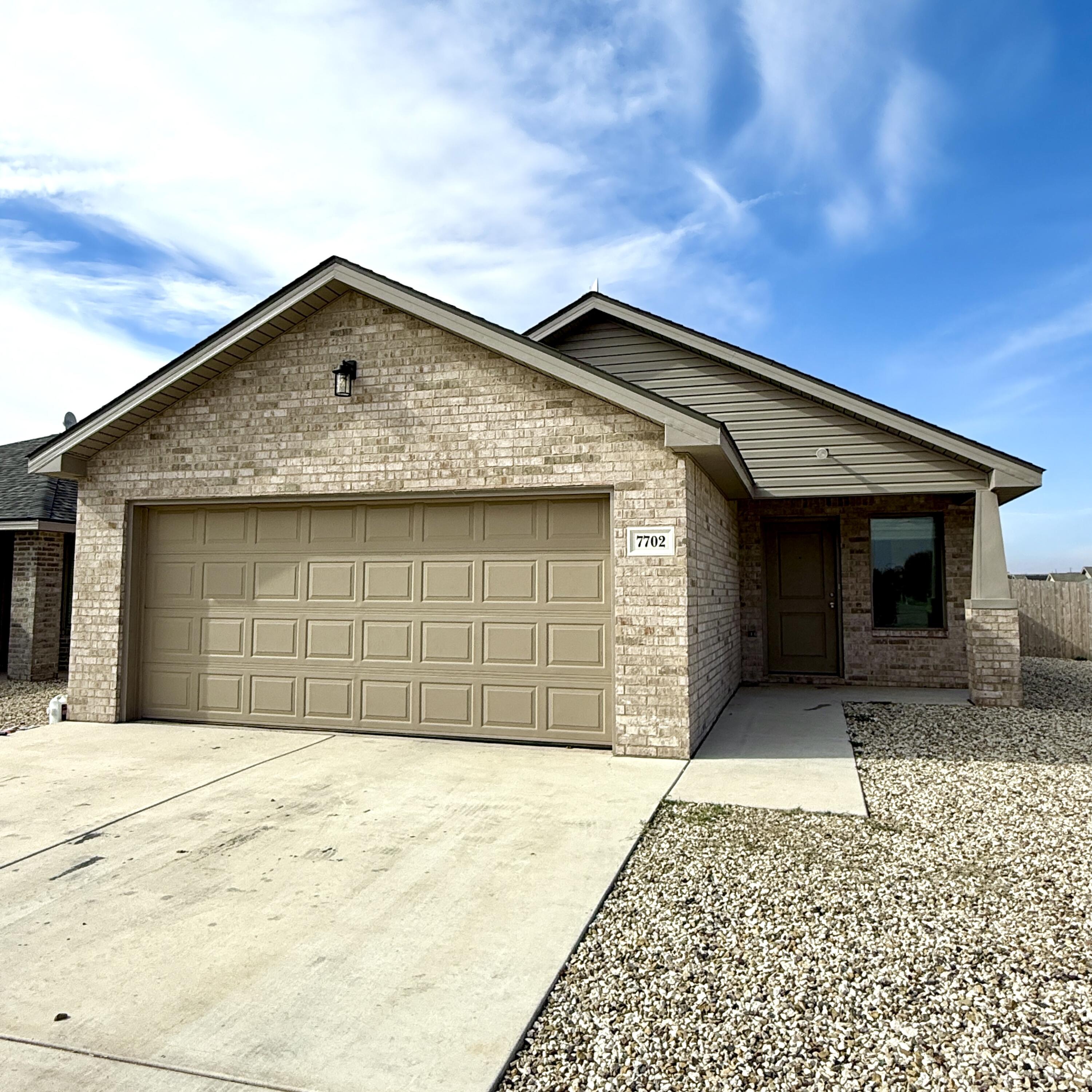 7702 Elm Avenue Lubbock, TX 79404 - Photo 1 of 16 a front view of a house with a yard