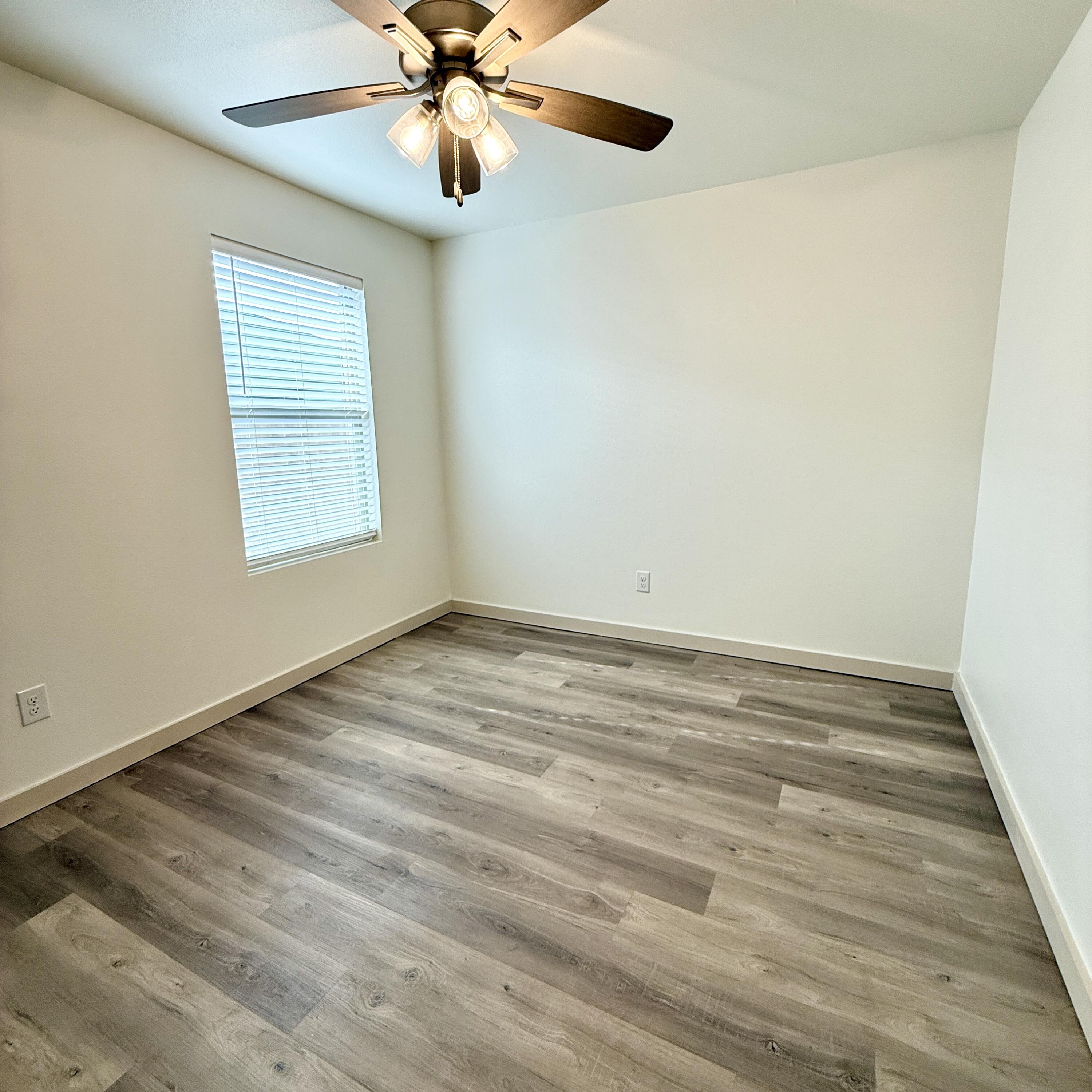 7702 Elm Avenue Lubbock, TX 79404 - Photo 12 of 16 an empty room with a window and a chandelier fan