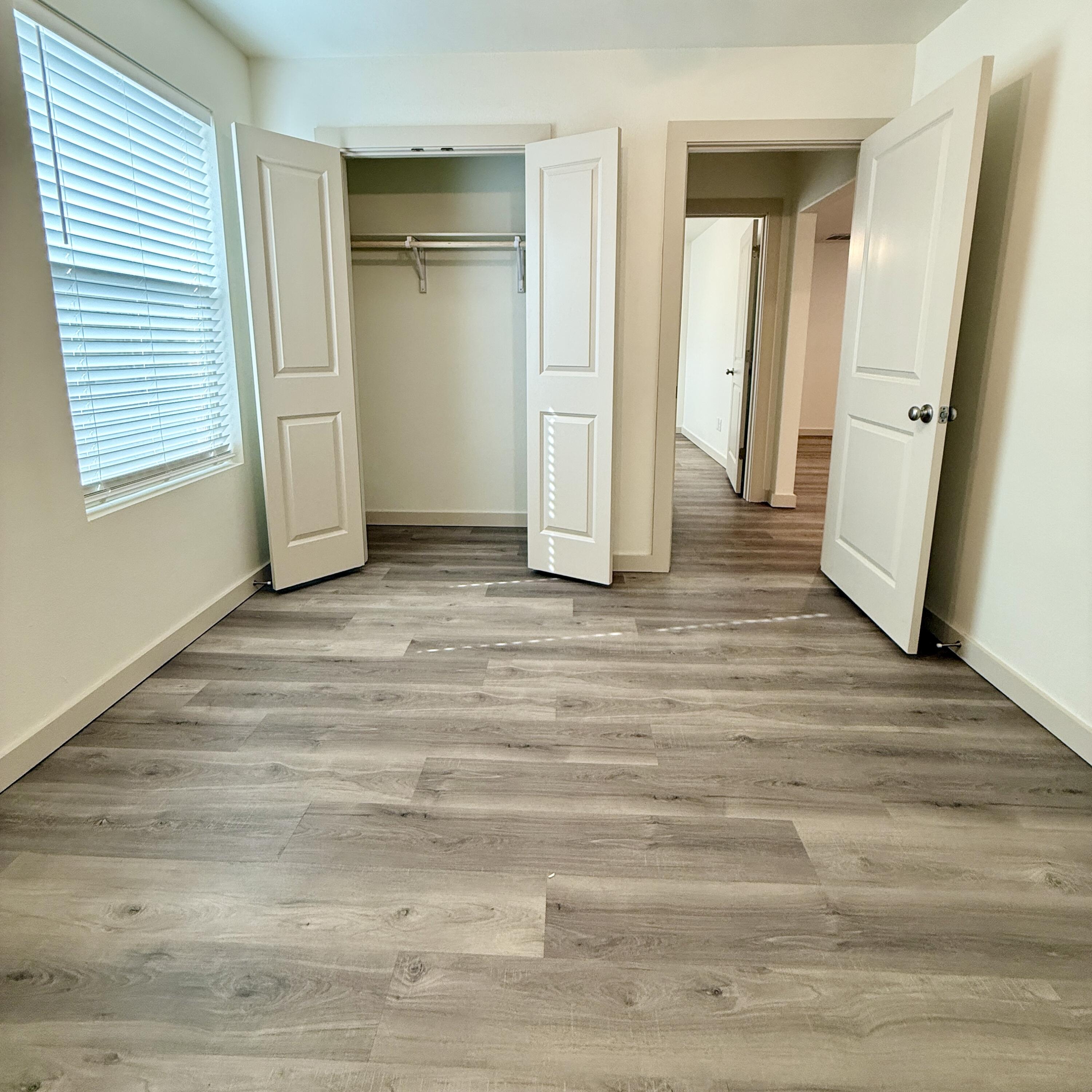 7702 Elm Avenue Lubbock, TX 79404 - Photo 14 of 16 a view of an empty room with wooden floor and a window