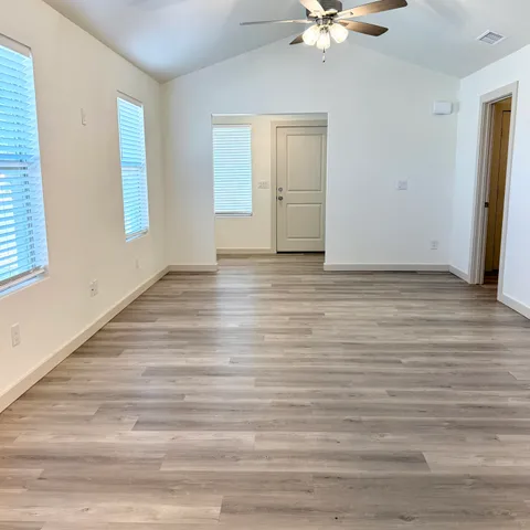 a view of an empty room with a window and a ceiling fan