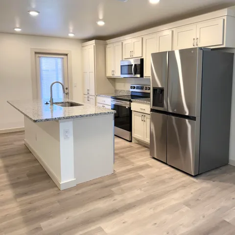 a kitchen with stainless steel appliances a refrigerator stove microwave and sink