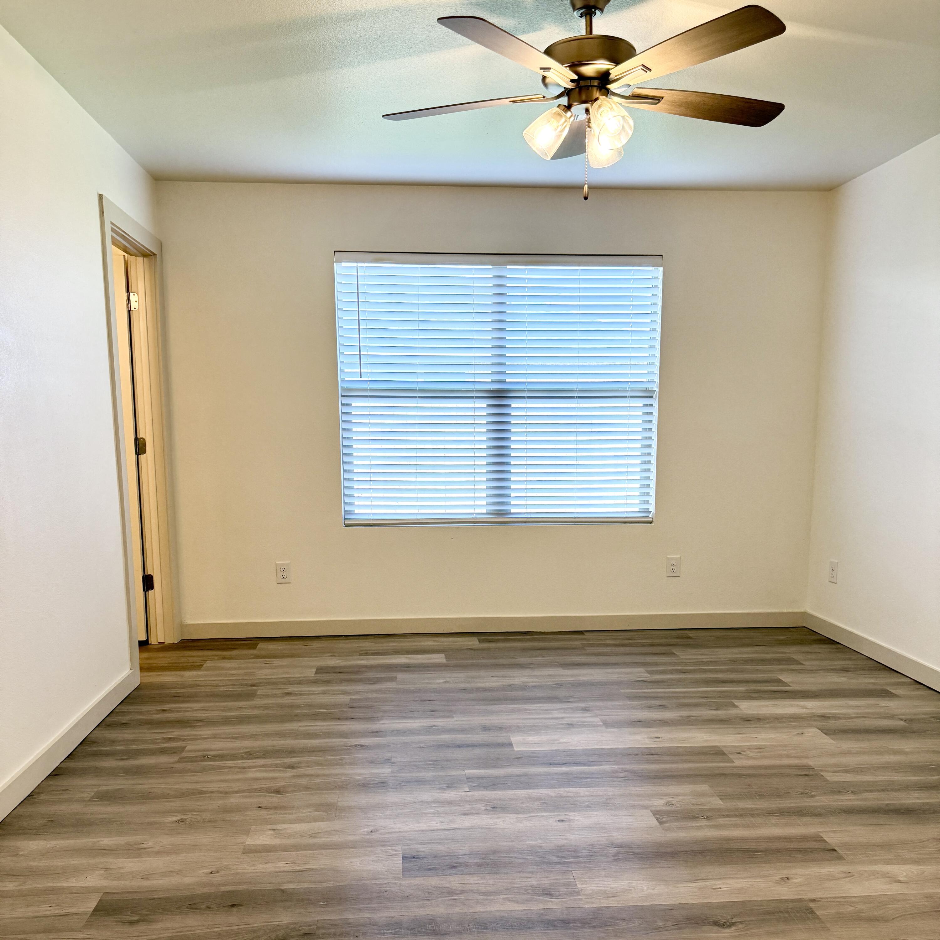 7702 Elm Avenue Lubbock, TX 79404 - Photo 5 of 16 an empty room with wooden floor fan and windows