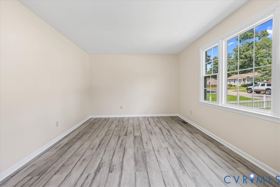 Unfurnished room with wood finished floors and bas