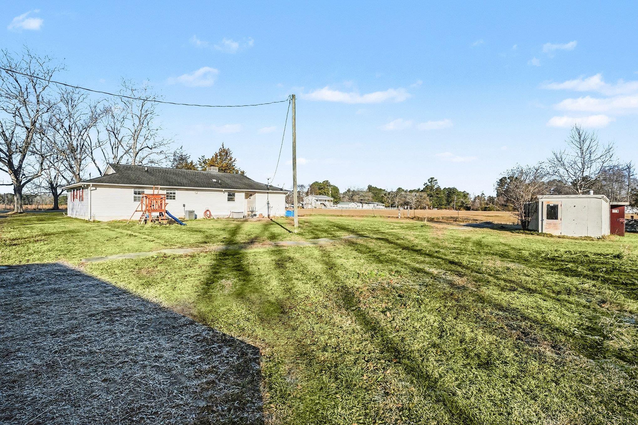 1897 Heritage Road Loris, SC 29569 - Photo 22 of 32 Rear view of house with a playground, a lawn, and a chimney