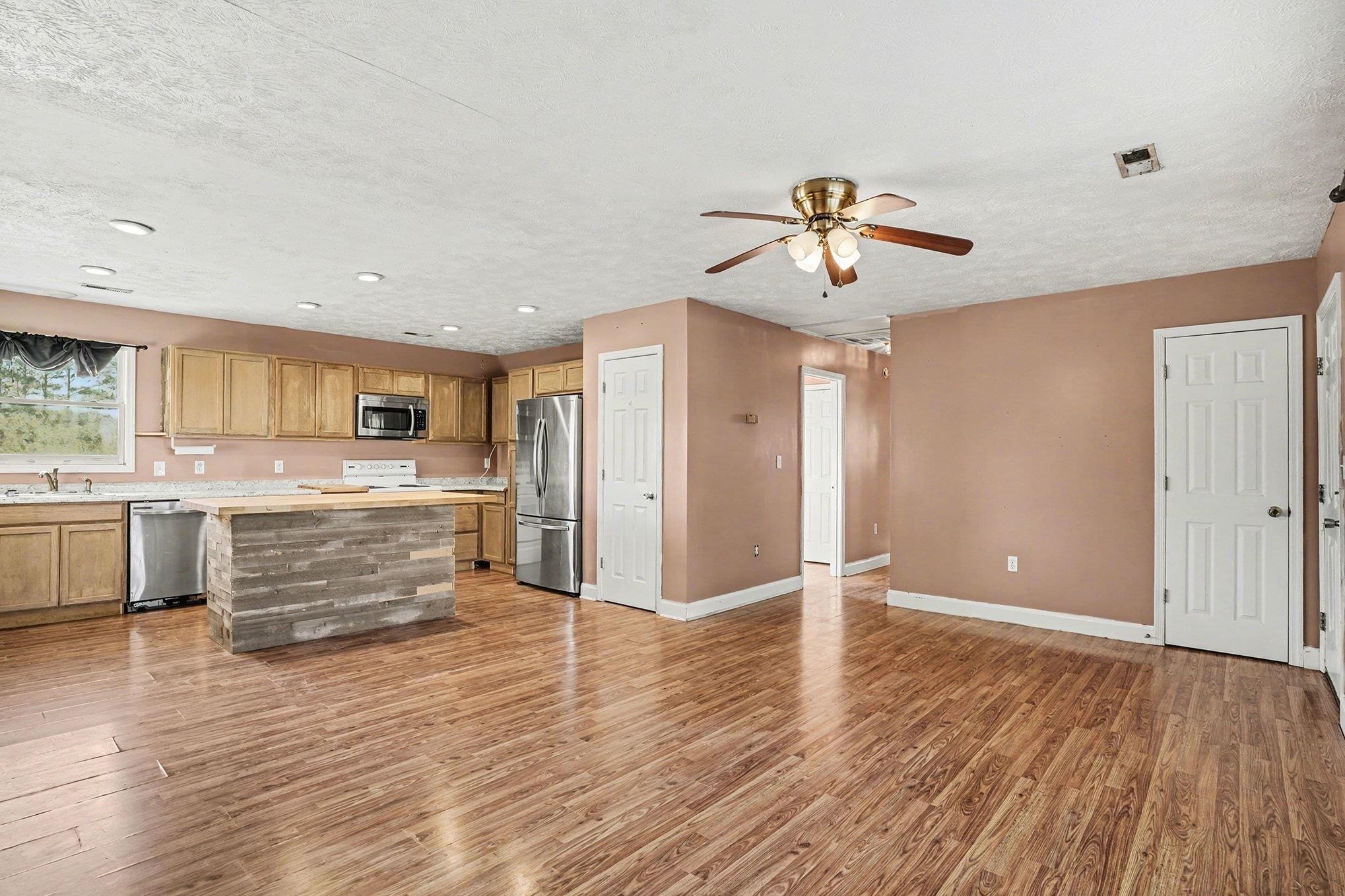 1897 Heritage Road Loris, SC 29569 - Photo 8 of 32 Unfurnished living room featuring a textured ceiling, light wood-style floors, and ceiling fan