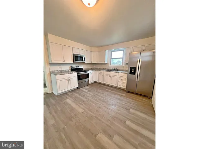 a large kitchen with a stove a sink dishwasher and a refrigerator