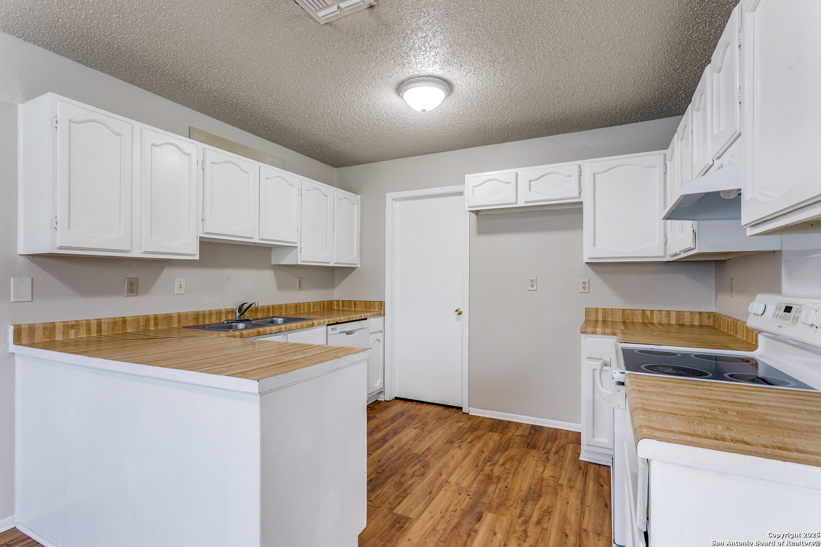 2803 Fred Haise Drive Kirby, TX 78219 - Photo 12 of 24 a kitchen with stainless steel appliances granite countertop a stove a refrigerator a sink dishwasher and white countertops with cabinets
