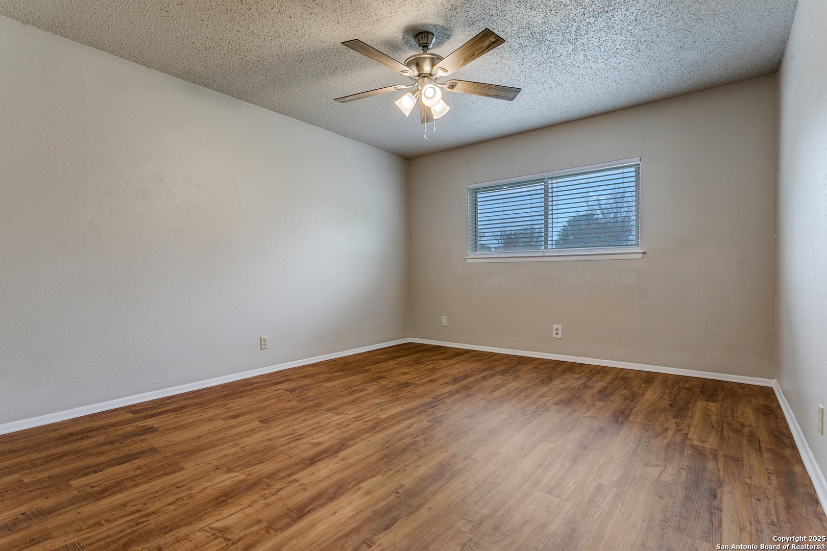 2803 Fred Haise Drive Kirby, TX 78219 - Photo 15 of 24 a view of an empty room with window and wooden floor