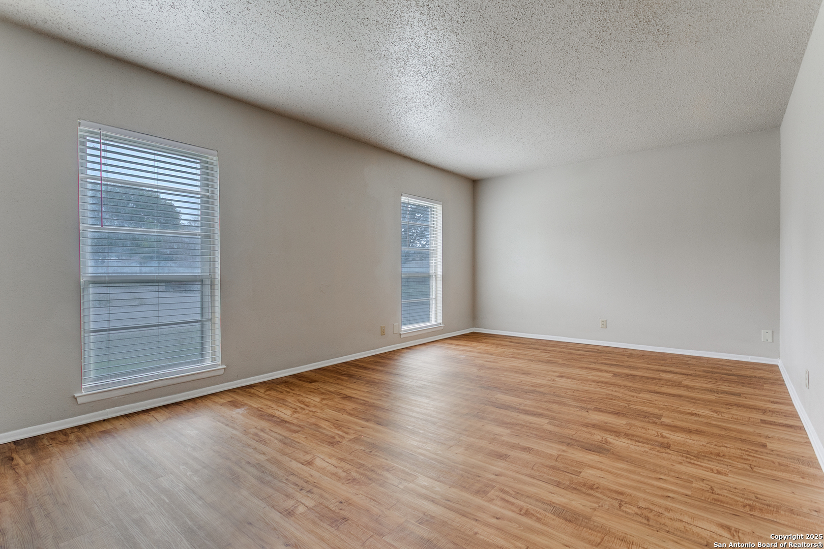 2803 Fred Haise Drive Kirby, TX 78219 - Photo 17 of 24 a view of an empty room with wooden floor and a window