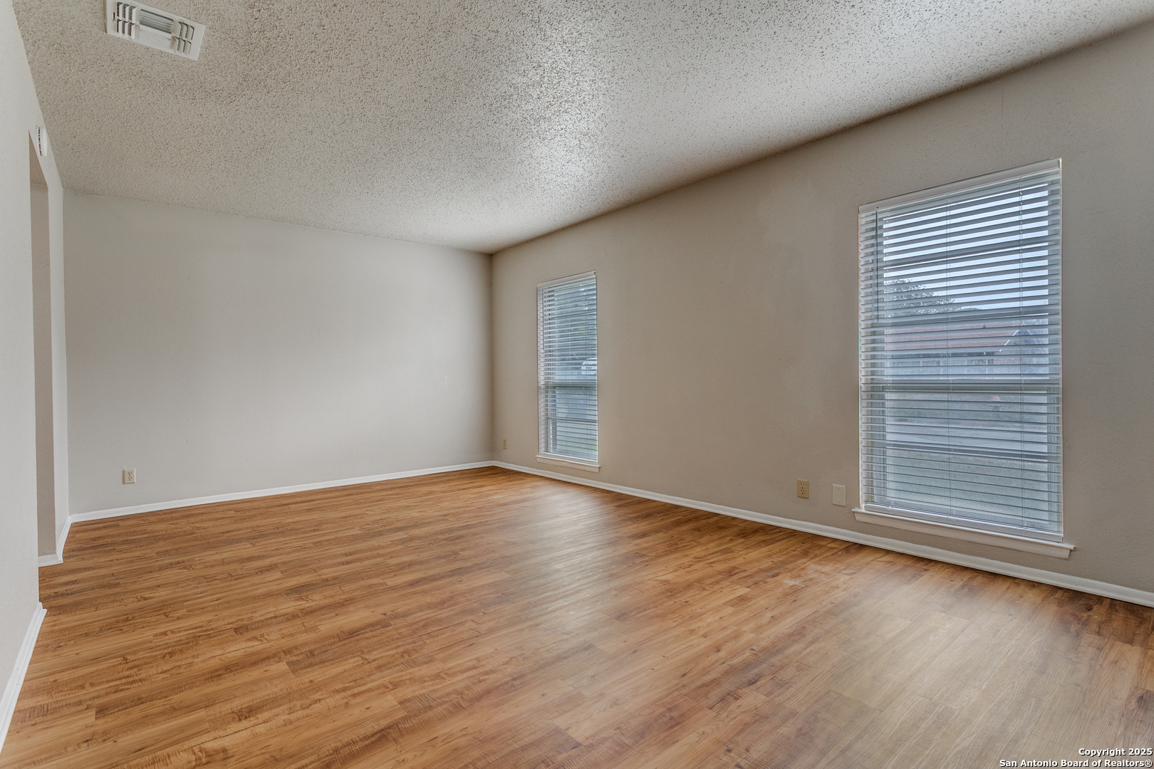 2803 Fred Haise Drive Kirby, TX 78219 - Photo 18 of 24 a view of an empty room with wooden floor and a window
