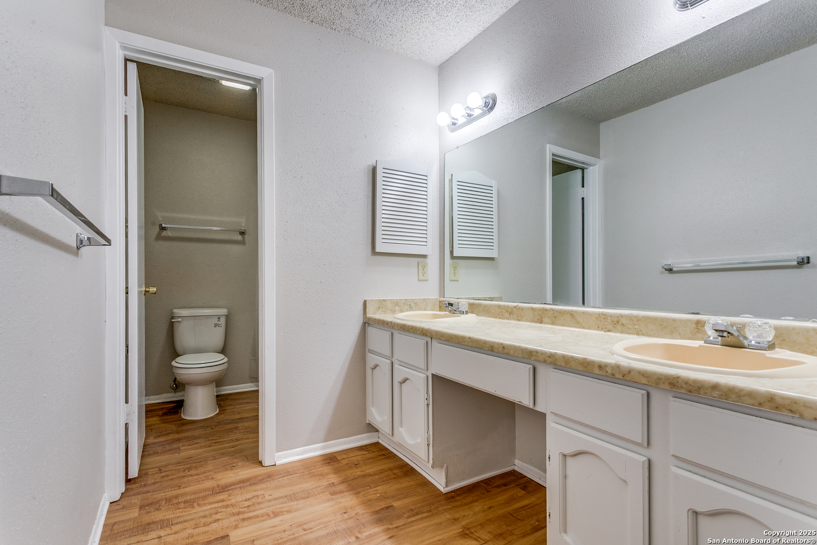 2803 Fred Haise Drive Kirby, TX 78219 - Photo 20 of 24 a bathroom with a granite countertop toilet sink and mirror