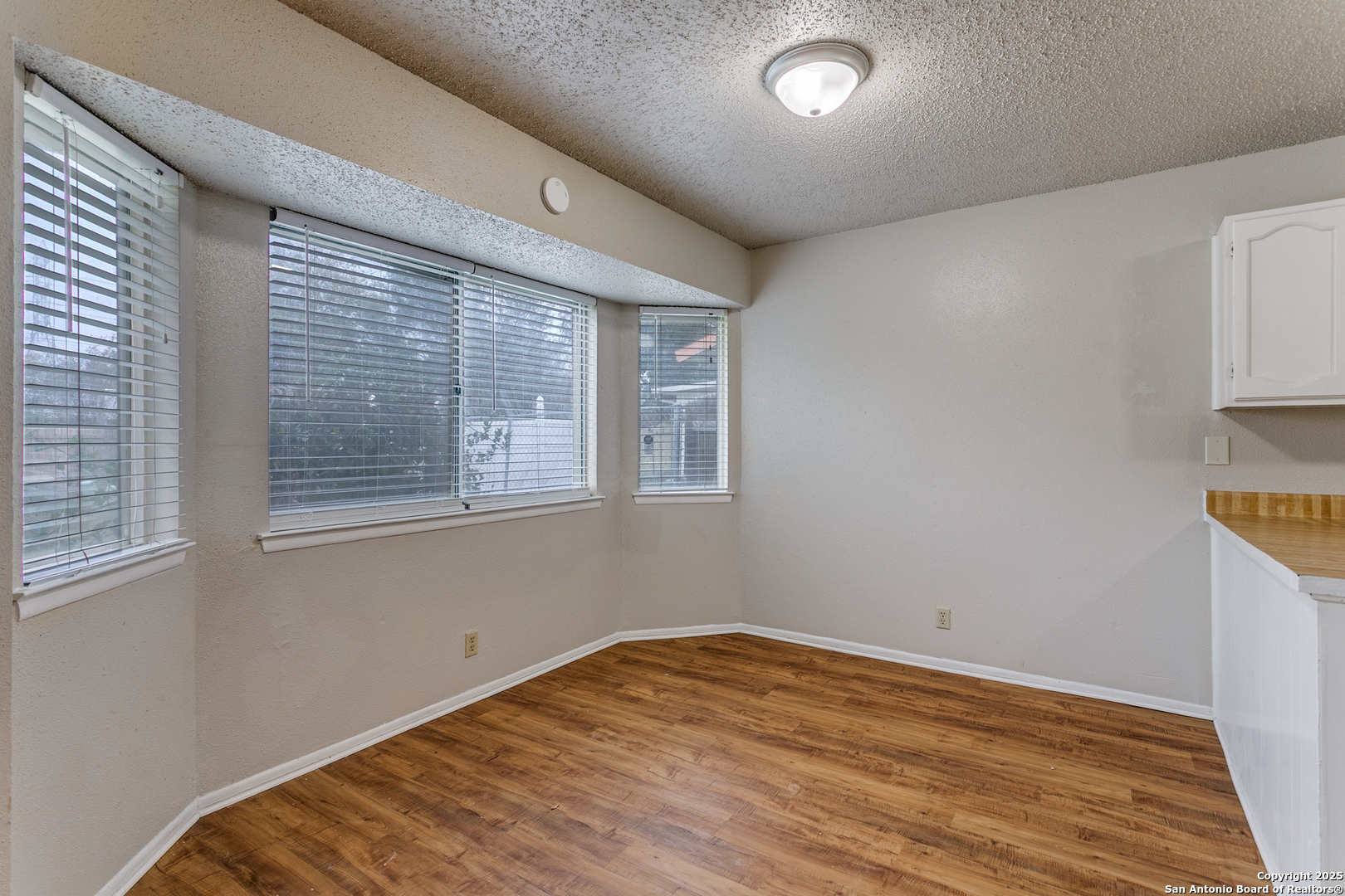 2803 Fred Haise Drive Kirby, TX 78219 - Photo 9 of 24 a view of empty room with wooden floor and fan