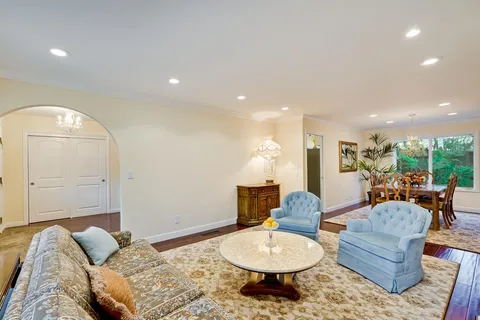 a living room with furniture and a dining table