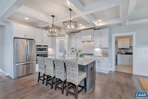 a kitchen with refrigerator a sink and chairs