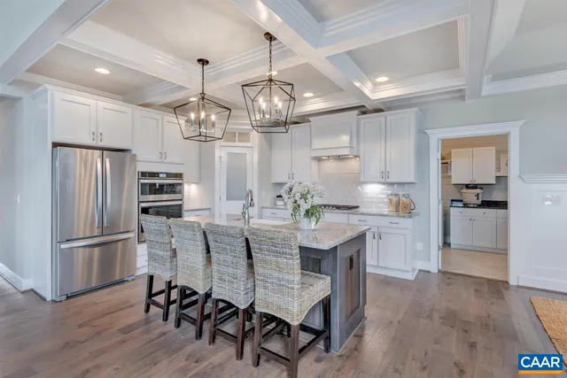 a kitchen with refrigerator a sink and chairs